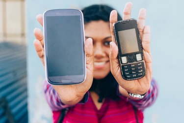 The smart phone on the left has more features than the older phone on the right.